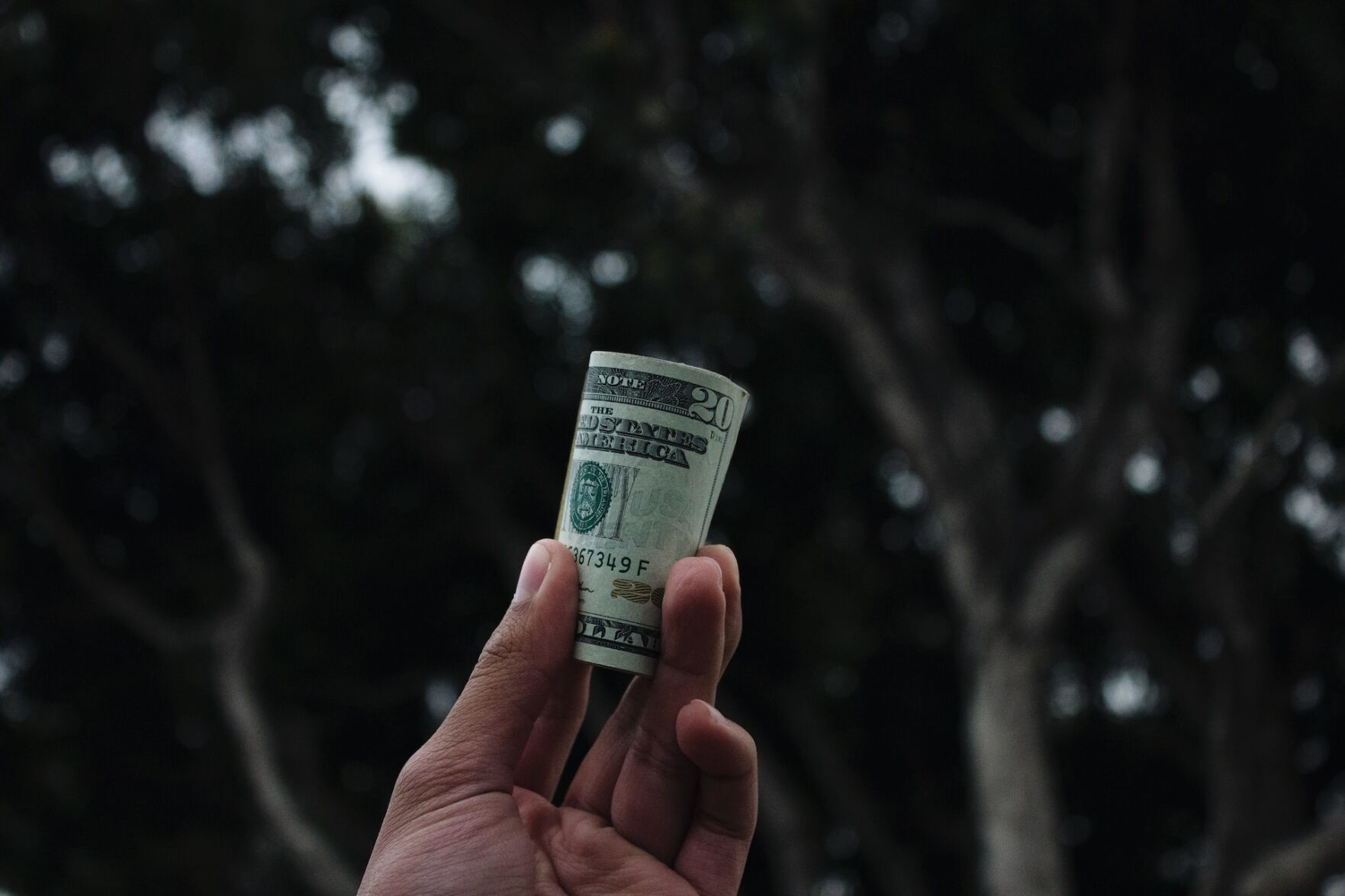Person holds up wad of dollar bills to symbolize money lending